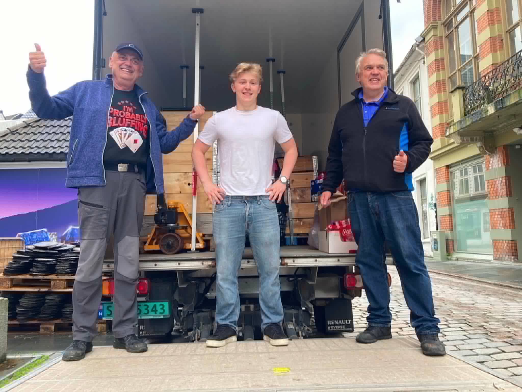 Frivillige med tommel opp foran en full lastebil under nedrigging av Bergen Spillfestival